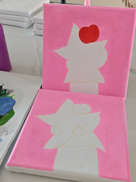 An apple and sketched character in acrylic on an entirely hand-painted pink canvas in progress